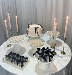 a white table topped with cakes and candles