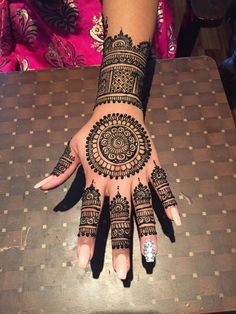 a woman's hand with henna tattoos on it