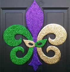 a purple and green mardi gras decoration on a door