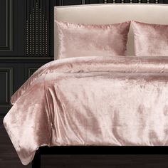 a bed with pink comforter and pillows on it