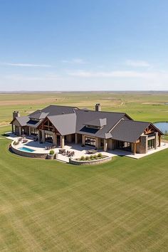 an aerial view of a large house in the middle of a field with a pool