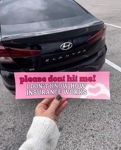 someone holding up a pink sign that says please don't hit me i don't know how insurance works