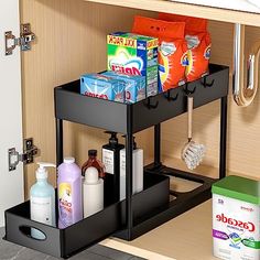 an open cabinet with cleaning products and toiletries on the bottom shelf in front of it