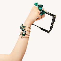 This stunning bracelet showcases a gorgeous emerald-cut crystal with a magnetic closure. The design is crafted from gold-tone metal with a PVC coating, and finished with a shiny luster coating. This piece is sure to add a touch of glamour to any outfit._ How to close and open it: to close, place one magnet on top of the other and slot together. To open, locate the small indent on the side of the magnetic closure and pop it open.- Bracelet measures approximately 2 1/4in x 1 3/4in-Swarovski's endu Modern Crystal Bracelets For Party, Elegant Green Crystal Metal Bracelet, Luxury Faceted Jewelry For Parties, Modern Party Jewelry With Stones, Elegant Green Faceted Crystal Bracelet, Unique Bangle, Crystal Green, Sunglasses Style, Trending Sunglasses