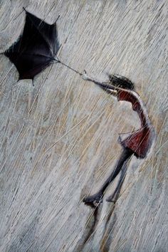 a woman holding an umbrella while walking in the rain with it's shadow on the ground