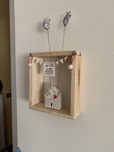 a small wooden shelf with some little decorations on it's sides, hanging from the wall