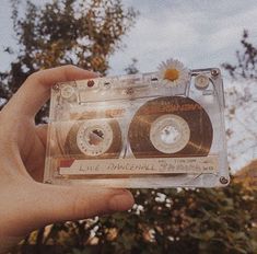 someone holding up an old fashioned cassette in their hand