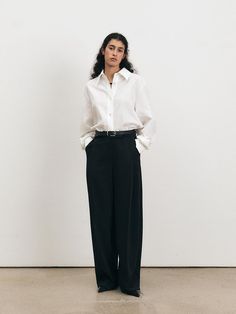 This Over Fit Shirt exemplifies modern minimalism with its oversized silhouette and crisp tailoring. The structured collar and clean button placket provide a timeless look, while the relaxed fit adds a contemporary edge. It's an ideal choice for those who favor a sophisticated yet unfussy aesthetic in their wardrobe. - The Over Fit Shirt is made from a breathable fabric, perfect for all-day comfort.- Its generous cut ensures ease of movement and a laid-back vibe.- The shirt's long sleeves and buttoned cuffs can be styled rolled up or down to suit different looks.- This versatile shirt can be paired with fitted trousers for contrast or worn with other loose garments for a fully relaxed ensemble. Classic Tailoring, Wide Trousers, Modern Minimalism, Fitted Trousers, Oversized Silhouette, Formal Shirts, Body Types, Workout Shirts, Breathable Fabric