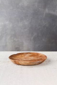 a wooden bowl sitting on top of a white table