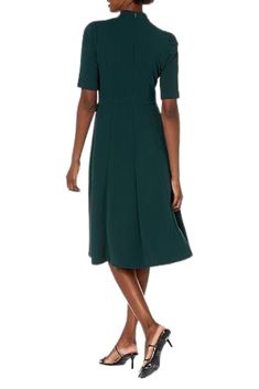 Effortless Elegance For a seamless transition from daytime receptions to elegant dinner parties, look no further than the Donna Morgan Mock Neck Crepe Fit and Flare Dress. Crafted with exquisite attention to detail and designed to flatter, this dress is the epitome of effortless elegance. The mock neck adds a sophisticated touch, framing your neckline with timeless allure. The fit and flare silhouette accentuates your curves while providing comfort and freedom of movement, making it perfect for Green V-neck Fit And Flare Dress, Green Fit And Flare V-neck Dress, Green Stretch Evening Dresses, Form-fitting Dark Green Dress For Wedding, Elegant Green Midi Evening Dress, Chic Fitted Dark Green Dress, Fitted Dark Green Dress For Wedding, Elegant Green Evening Midi Dress, Chic Green Dress For Formal Occasions