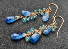 "Blue Kyanite and Apatite Gemstone Earrings Beautiful cobalt blue Kyanite briolettes and Apatite beads wrapped with high quality 14k gold filled wire and swings from a gold filled chain. Dangly, delicate, these are an elegant and feminine, chic statement earrings, perfect for special occasion, wedding, holidays or as a Gift for Her. These are natural, excellent AAA quality gems. Each briolette is faceted beautifully and sparkle with every movement. Measurements: Kyanite Briolette : 7-10mm The ea Blue Apatite Gemstone Earrings, Handmade Blue Apatite Earrings, Blue Apatite Earrings For Gift, Blue Apatite Earrings Gift, Blue Earrings For Gift, Blue Apatite Jewelry, Apatite Jewelry, Kyanite Earrings, Blue Beaded Earrings