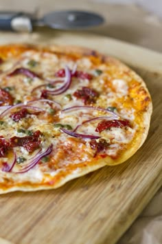 a pizza sitting on top of a wooden cutting board