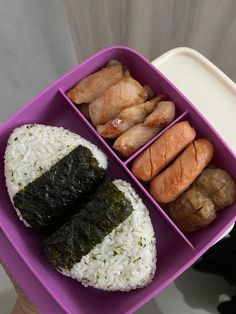 a person holding a purple tray with rice and sushi in it