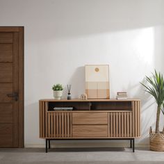 a wooden sideboard sitting next to a potted plant