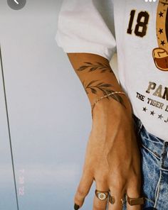 a person with tattoos on their arms and fingers