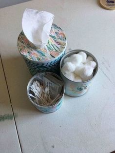 two tins filled with cotton sitting on top of a table