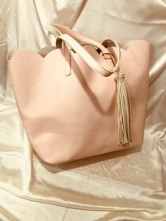 "Vintage  - A pink pastel slightly textured vinyl tote with a scalloped \"collar\", a pair of 3/4\" x 21\" straps and a snazzy oversized pink vinyl tassel.  The inside is a smooth wide open white vinyl - simple - roomy and unadorned.   Pretty and practical - shop with style! * dimensions: 15\" wide at base                         18\" wide at top x 13 1/2\" tall x 6\" deep * easily wipes clean * excellent condition Please note: ALL my bags are carefully hand cleaned to ensure a pristine freshnes Chic Blush Shoulder Bag For Spring, Spring Shopping Shoulder Bag In Blush, Spring Blush Shoulder Bag For Shopping, Large Pink Shoulder Bag For Shopping, Feminine Pink Shoulder Bag For Spring, Feminine Blush Tote Shoulder Bag, Chic Pink Shoulder Bag For Spring, Spring Shopping Pink Shoulder Bag, Spring Pink Shoulder Bag For Shopping