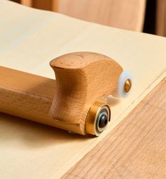 a close up view of a wooden object on a table with wood grained surface