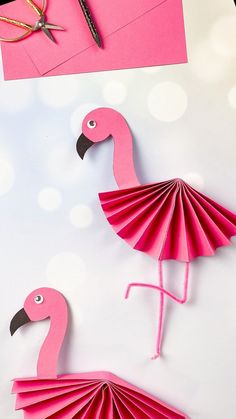 two pink flamingos made out of folded paper