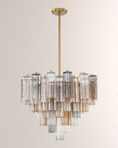 a chandelier made out of glass blocks hanging from a gold ceiling light fixture