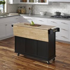 a kitchen island with cutting board on it in the middle of a hardwood flooring area