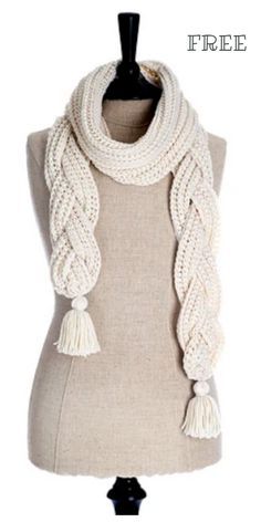 a white knitted scarf on top of a mannequin headdress with tassels