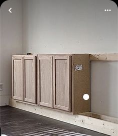 an unfinished kitchen cabinet in the middle of a room with white walls and wood flooring