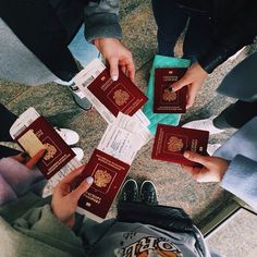 several people are holding their passport in the middle of a circle, with one person's hands on top of them