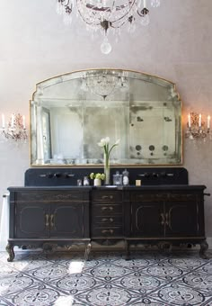 a fancy bathroom with chandelier and double sinks