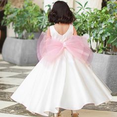 This elegant white Dubai girl dress features delicate pearls, adding a touch of luxury to this beautiful gown. Perfect for weddings, birthdays, and holiday parties, it's a princess-worthy outfit that will make your little one feel like royalty. Expertly crafted for a perfect fit, it's sure to make your child's special occasion even more magical. Princess Dress With Satin Bow For Dress-up, Pageant Tulle Dress With Satin Bow, Tulle Dresses With Satin Bow For Pageants, Tulle Dress With Satin Bow For Pageant, Dress-up Tulle Dress With Satin Bow, Princess Style Ball Gown With Satin Bow For Party, Tulle Dress With Satin Bow For Dress-up, Elegant Ball Gown With Satin Bow For Pageant, Elegant Sleeveless First Communion Dress