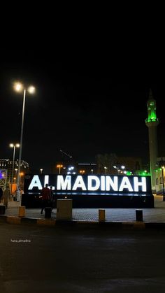 a large sign that reads al madinah at night