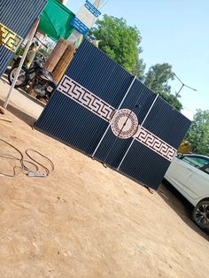 a white car parked in front of a blue gate