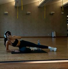 a woman is doing an exercise with headphones on her ears and in the middle of a yoga pose