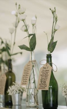 three vases with flowers in them are labeled with names and price tags on the bottles