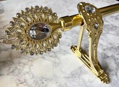 a gold colored metal object on a marble counter top with crystal stones in the center