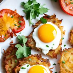 an egg is on top of potato chips with tomatoes and parsley next to it