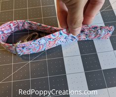 someone is cutting out the fabric for an origami style ring holder with scissors