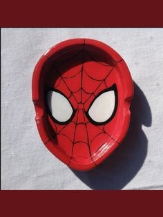 a red bowl with a spider - man face painted on the side and eyes drawn out