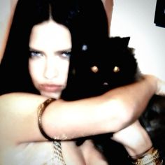 a woman holding a black cat in her arms