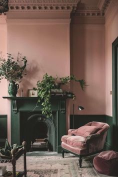 a living room filled with furniture and a fire place in front of a pink wall