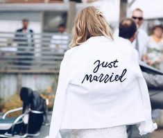 the back of a bride's jacket that says just married in black on it