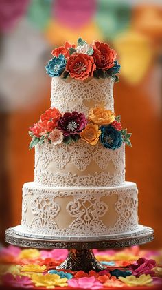 a three tiered wedding cake decorated with paper flowers