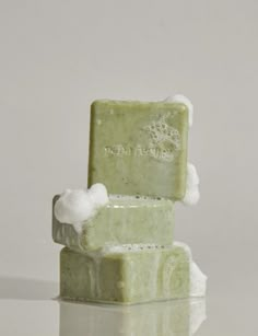 two soap bars stacked on top of each other in front of a white background with reflection