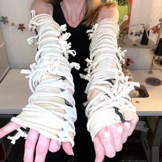 a woman with her hands wrapped in white laces and showing off the thumbnails