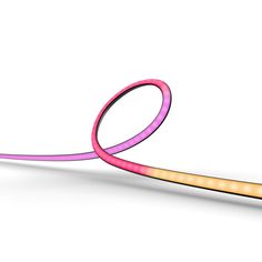 a pair of pink and yellow scissors on a white surface with light coming from them