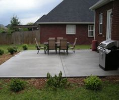 a patio with chairs, grill and table in the back yard