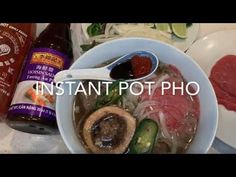 a bowl filled with meat and vegetables on top of a white plate next to a bottle of ketchup