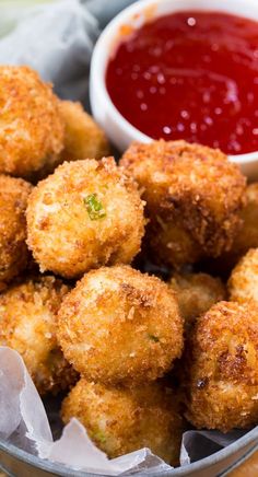 some fried food is in a bowl with ketchup on the side and sauce