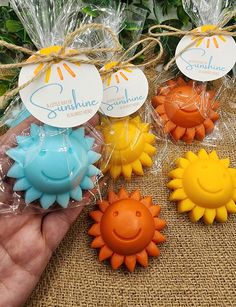 small sunflower soaps are being held by someone's hand with tags on them