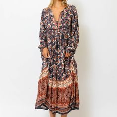 Our Sienna Maxi Dress Is The Perfect Mixture Of Bohemian Vibes And Americana With Its Rich Hues Of Navy Blue, Burnt Umber And Warm Ivory. Dress Features A Deep V-Neckline With Double Tassel Tipped Drawstrings, And A Ruffled Hem. 100% Rayon Model Is 5'7 And Wearing A Size Small Bust 32 | Waist 24 | Hips 34 Bohemian Orange Maxi Dress For Fall, Blue Bohemian Maxi Dress For Fall, Orange Bohemian Long Sleeve Maxi Dress, Orange Long Sleeve Bohemian Maxi Dress, Bohemian Orange Maxi Dress For Day Out, Orange Long Sleeve Boho Dress, Orange Long Sleeve Bohemian Dress, Blue Boho Beach Dress For Fall, Blue Bohemian Dress For Fall